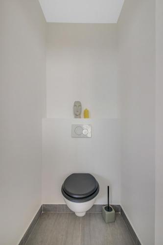 La salle de bains est pourvue de toilettes noires et d'un siège noir. dans l'établissement Chic, central à deux pas de Beaugrenelle I, à Paris