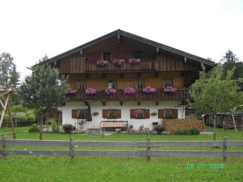 una gran casa de madera con flores en las ventanas en Ferienwohnung Regauer, en Fischbachau