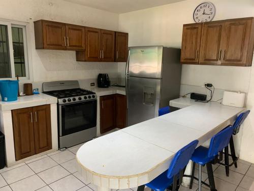 uma cozinha com uma mesa, um frigorífico e armários em Chalet Casa Vacacional Riveras de Chulamar em Puerto San José