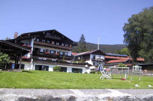 a large building with a table and chairs in the grass at Ferienwohnungen am See _ Hinterseer in Schliersee