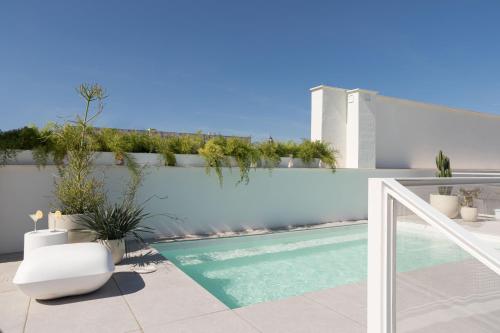 un balcone con piscina e recinzione bianca. di Mylu Suites by Puerta Catedral a Siviglia