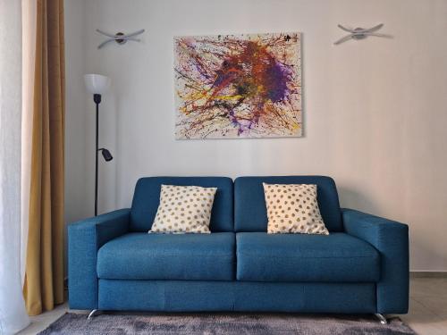 um sofá azul com duas almofadas numa sala de estar em Quick Flat - Milan Central em Milão