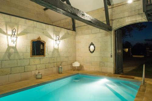 an indoor swimming pool in a stone building with a pool at La Folie Saint Julien in Saint-Julien-de-Chédon