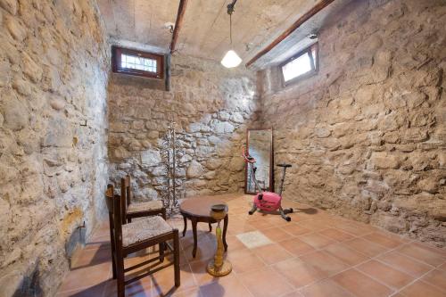 a room with a stone wall with a table and a chair at Wakesurfhouse in Sulzano