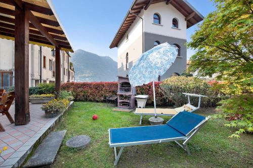 a yard with a blue chair and an umbrella at Wakesurfhouse in Sulzano