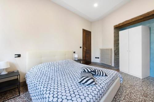 a white bedroom with a bed with striped pillows on it at Wakesurfhouse in Sulzano