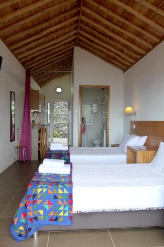 two large beds in a room with a kitchen at Casas Goulart in Canto da Areia