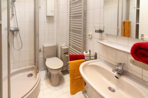 ein Badezimmer mit einem WC, einem Waschbecken und einer Badewanne in der Unterkunft Ferienhaus Kim in Dornumersiel