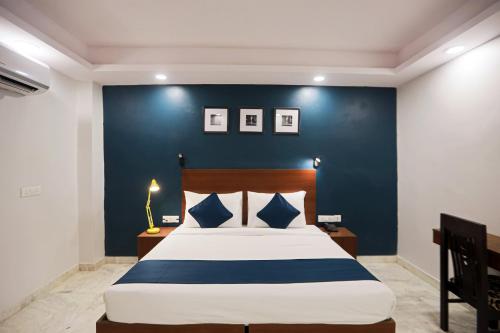 a bedroom with a large bed with a blue wall at OYO SILVERKEY EXECUTIVE RC Near ISKCON Temple Noida in Indirapuram