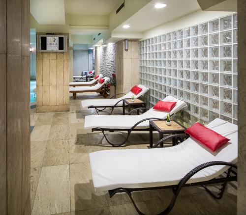 a waiting room with white chairs and red pillows at Orka Royal Hotel & Spa in Istanbul