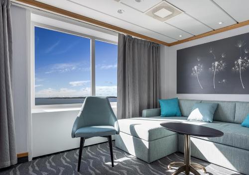 a bedroom with a couch and a table and a window at Viking Line ferry Gabriella - One-way journey from Helsinki to Stockholm in Helsinki