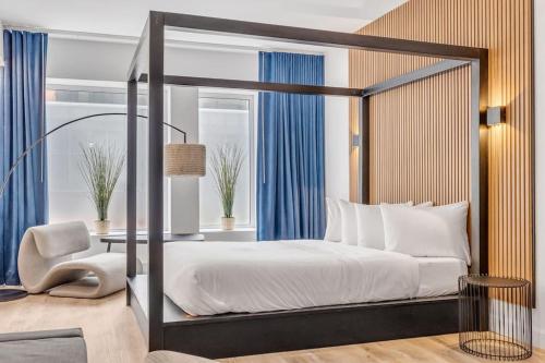 a bedroom with a canopy bed with a table and a chair at Initial / Libre / Centre-ville de Quebec in Quebec City