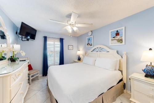 a bedroom with a white bed and a ceiling fan at Islander E 4009 in Fort Walton Beach