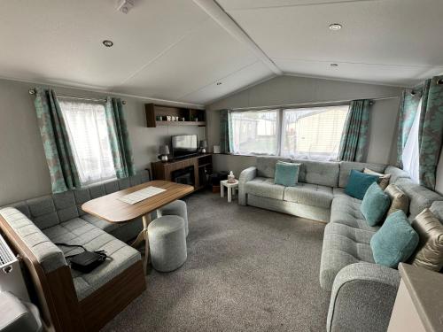 a living room with a couch and a table at Seton Sands St Andrews in Port Seton