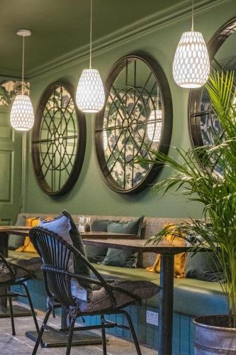 a room with chairs and tables and circular windows at The Black Lion, Long Melford in Long Melford