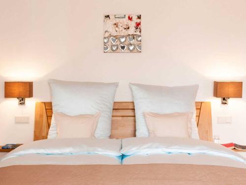ein Schlafzimmer mit einem Bett mit weißen Kissen in der Unterkunft Ferienwohnungen Nutz in Bad Wiessee