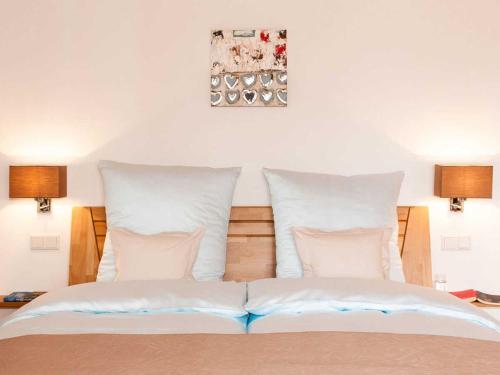 Un dormitorio con una cama con almohadas blancas. en Ferienwohnungen Nutz, en Bad Wiessee