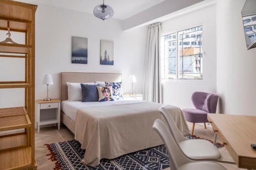 Un dormitorio con una cama, un escritorio y una silla. en Apartamentos Progresso 1º Esq, en Funchal