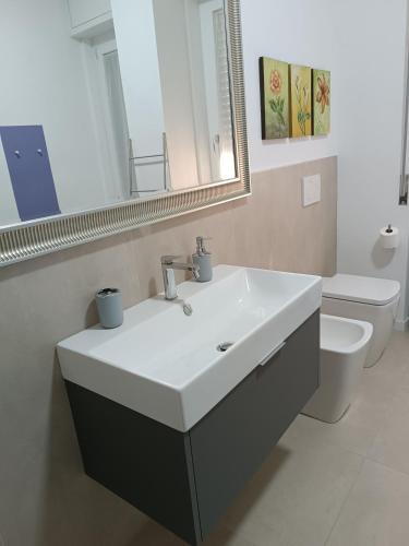 a bathroom with a sink and a toilet and a mirror at il 64B - 10 minuti a piedi dal Policlinico San Matteo - in Pavia