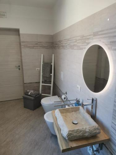 uma casa de banho com um lavatório, um WC e um espelho. em LONATE ROOM em Lonate Ceppino