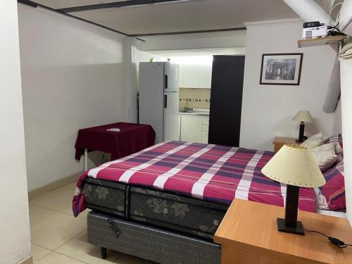 a bedroom with a bed and a desk with a lamp at Monoambiente Playa Nebel in Concordia