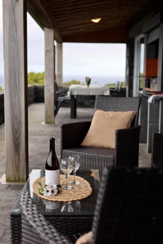 a bottle of wine sitting on a table with glasses at Casas Goulart in Canto da Areia