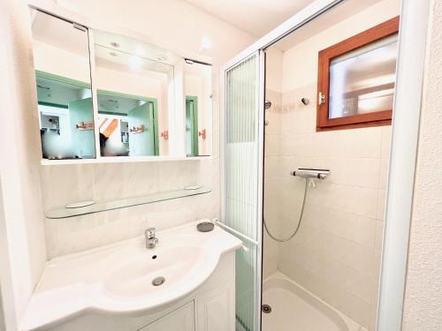 une salle de bain avec un lavabo et une douche dans l'établissement Appartement Les Lauriers, à Cavalaire-sur-Mer