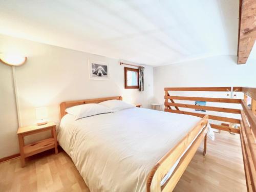 une chambre avec un grand lit blanc et un escalier dans l'établissement Appartement Les Lauriers, à Cavalaire-sur-Mer