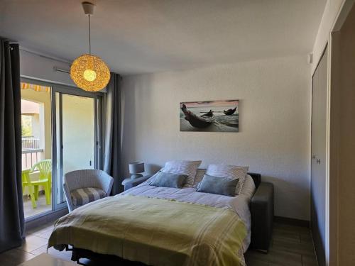 sypialnia z łóżkiem i krzesłem w obiekcie Petit paradis classé 3 étoiles à 200m de la plage! Terrasse-Wifi-Parking-clim w mieście Saint-Mandrier-sur-Mer