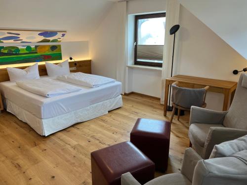 a bedroom with a bed and a couch and a chair at Aparthotel Parsberg LFerstl in Parsberg