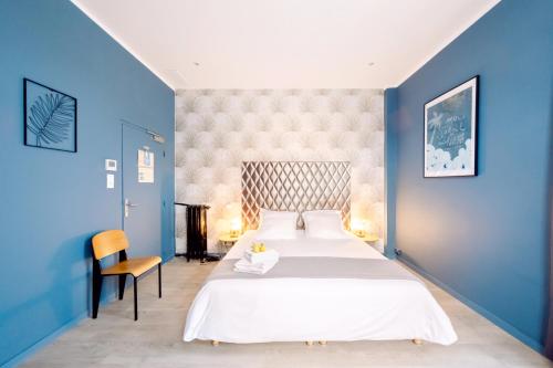 マントンにあるHotel Lemonの青い壁のベッドルーム1室(大型ベッド1台付)