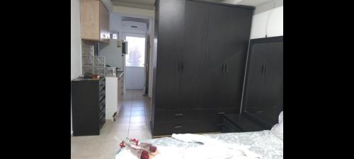 a kitchen with black cabinets and a bed in a room at יחידת דיור שקטה נעימה in Nahariyya