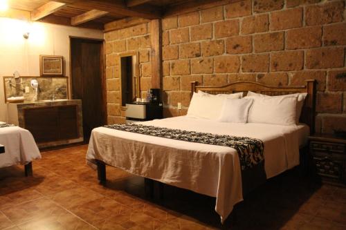 1 dormitorio con 1 cama grande en una pared de ladrillo en Hotel Real Nirvana, en Tecozautla