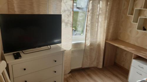 a flat screen tv on a dresser with a window at Jurmala's Centre Apartments in Jūrmala