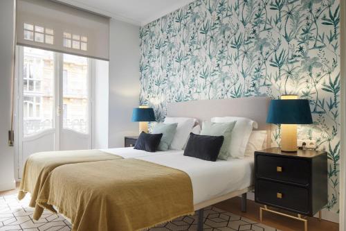 サン・セバスティアンにあるUrbieta 3 by FeelFree Rentalsの花柄の壁紙を用いたベッドルーム1室(大型ベッド1台付)