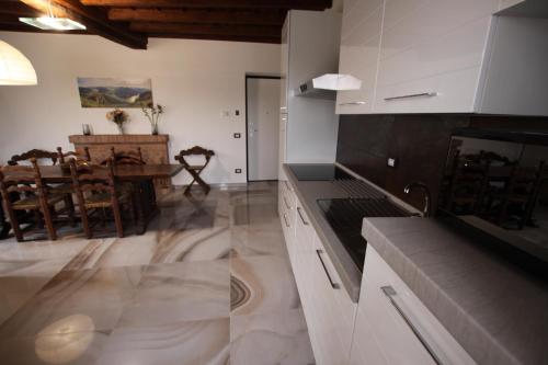 a kitchen with a stove and a dining room at casa airuno in Airuno