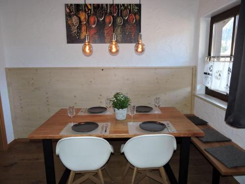 a wooden table with white chairs and a dining room at Chalet Alpenflair in Pfronten