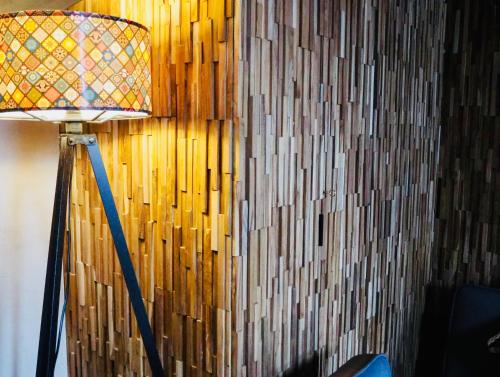 une lampe devant un mur avec un mur en bois dans l'établissement El PENTHOUSE de La Casa Rebonita, à Candelario