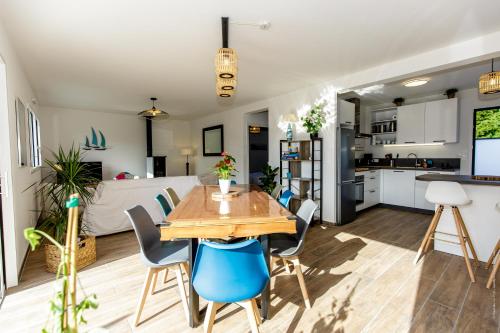 une cuisine et une salle à manger avec une table et des chaises en bois dans l'établissement MAISON NEUVE LUMINEUSE AU CALME PROCHE DES PLAGEs, à Quiberon