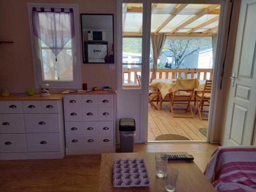 sala de estar con muebles blancos y puerta corredera de cristal en Mobil-home camping 