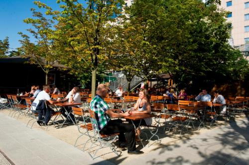 a group of people sitting at tables in a park at Estrel Berlin in Berlin