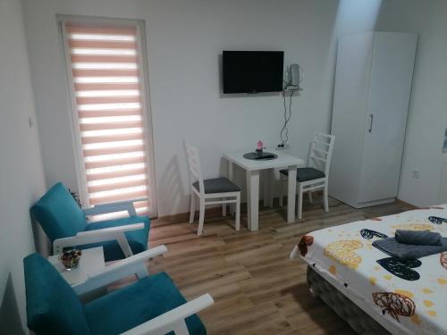 a room with a bed and a table and chairs at Apartmani Ružina staza in Rudnik Kačerski