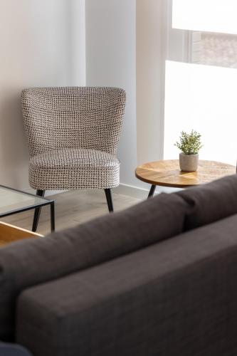 a living room with a chair and a couch and a table at INSIDEHOME Ciudad de Valladolid in Valladolid