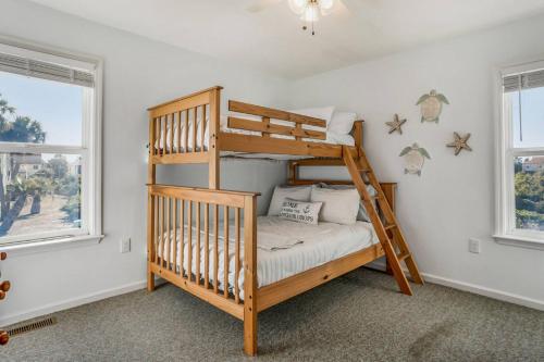 a bedroom with a bunk bed and two windows at Harbor Island 2 Ebb Tide Ct in Oceanmarsh Subdivision