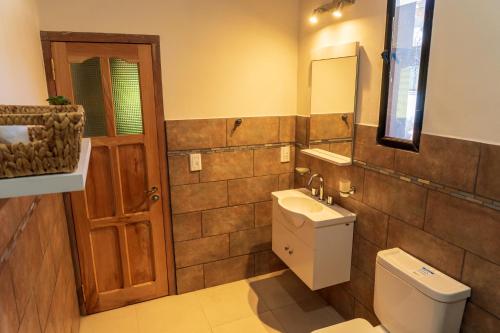 La salle de bains est pourvue de toilettes, d'un lavabo et d'un miroir. dans l'établissement HOSPEDAJE LA CASONA DE CACHI, à Cachí