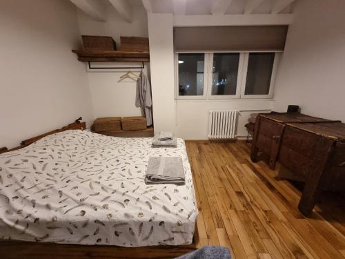 a bedroom with a bed and a wooden floor at City centre 'Farmhouse in the Sky' designer apt. in Pristina