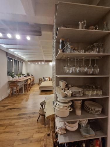 a room with shelves filled with plates and dishes at City centre 'Farmhouse in the Sky' designer apt. in Pristina