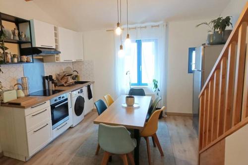 une cuisine avec une table et des chaises dans une pièce dans l'établissement Loft en centre ville, à Perpignan