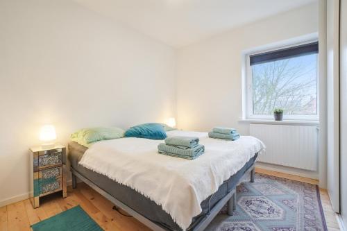 a bedroom with a bed with two pillows on it at Delicius apartment near the Beach,Metro, Airport in Copenhagen