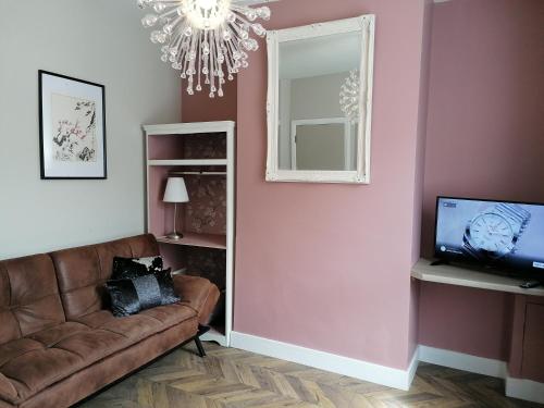 a living room with a couch and a mirror at Stunning 3 Bedroom townhouse in the heart of city in Belfast